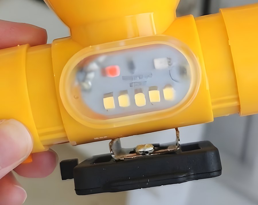 Close-up of the JH-238 side light window with its red signal LED and five white LEDs, above the black helmet clip